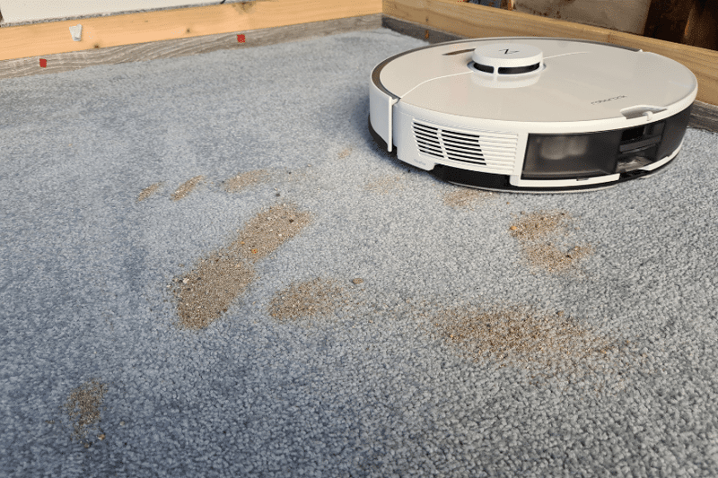 Roborock S7 Pro Ultra vacuum robot cleans sand on a high pile carpet.